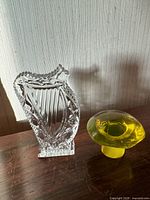 Front view of Waterford Crystal harp and yellow-green glass mushroom on wood surface