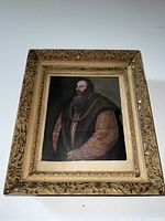 Photo showing full view of the 19th century portrait painting framed in ornate decorative gold-colored frame with floral and scroll designs.