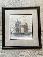 Framed artwork of Tower Bridge London in a dark wooden frame with a beige mat.