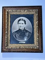 Framed charcoal portrait drawing shown front-on, highlighting detailed artwork and frame materials.