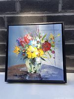 Frontal view of the painting featuring bright colorful flowers in a white vase on a neutral background.