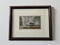 Framed print showing a girl, dog, and baby carriage outside a white picket fence in a garden setting.
