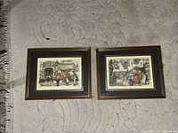 Pair of framed Anton Pieck art prints side by side on textured carpet.