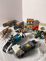 Front view showing the speeder bike, X-Wing cockpit, house, trucks and mini-figures arranged on a flat surface.