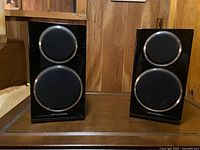 Front view of both speakers showing black gloss baffles, circular cloth-covered drivers, silver Wharfedale logos