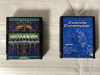 Two Atari 2600 video game cartridges Beamrider and Cosmic Commuter side by side on a textured surface.