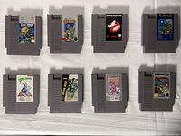 Eight grey NES cartridges arranged in two rows of four on white cloth