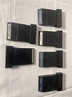 Six Nintendo game cartridges laid flat on a light-colored table, showing labels for Football Players, Astroblast, Baseball, Armor Ambush, Dark Cavern and Frogs and Flies.