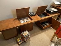 Wide view of the vintage wooden console with the amplifier and tuner revealed under lift-up wooden lids, Sony tape deck on top, and built-in speakers.