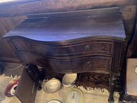 Front angled view of the antique Victorian buffet showing the curved front drawers, dark stained wood, and original hardware.