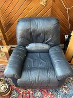 Blue Lazy Boy reclining chair, front view showing cushioned armrests and back with leather upholstery and signs of light wear.