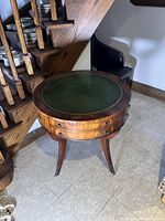 Front view of the round mahogany drum table showing overall form and drawer tiers