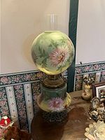 Full view of the two-piece lamp showing top globe, font, burner, chimney, and base