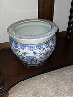 Photo of round vintage Chinese porcelain flower vase showing cobalt blue floral patterns and Greek key rim design on white background.
