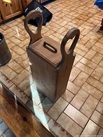 Side-angle view of teak wood bread basket showing one handle and side panel