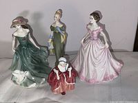 Four figurines grouped on white cloth background