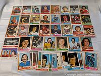 Top-down view of roughly 45 laid-out 1974-75 OPC hockey cards showing key players