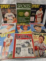 Front covers of seven vintage baseball magazines displayed upright and flat