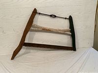 Antique wooden frame saw showing overall shape and size from the front view.