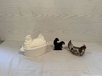 Image showing all three farmhouse-themed items: metal rooster napkin holder, white ceramic hen soup tureen, and nesting hen planter