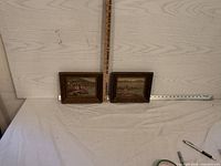 Photo showing both framed seaside prints side by side with measuring tools indicating size.