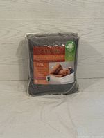 Packaged full size heated plush electric blanket showing front label and controller image, dark gray color.