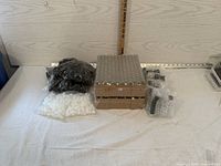 Photo of unopened packages containing several black-capped glass roller bottles for essential oils packed in cardboard trays and plastic bags.