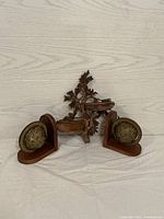 Full view of the set including two wooden globe bookends and a central carved wooden trinket shelf on a white background.