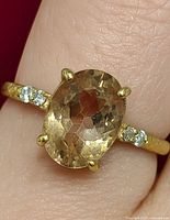 Ring on finger showing top view with oval morganite and diamond accents