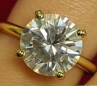 Close-up view of round brilliant-cut moissanite in gold prong setting