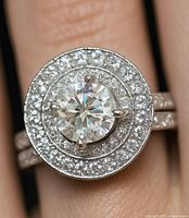 Close-up of the silver ring worn on finger showing the 2ct moissanite center surrounded by 0.5ct cubic zirconia stones in halo design.