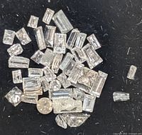 Close-up view of multiple small mixed-cut diamonds on black background.
