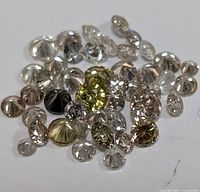Close-up photo showing a variety of natural fancy color diamonds with different colors and cuts.