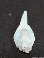 Top down view of the hand carved Australian opal figurine showing the sculpted flower detail.