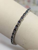 Close-up front angled view of the shiny silver bracelet with multiple iridescent mystic topaz stones.