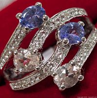 Close-up of the silver ring showing two blue tanzanite and two pink morganite stones with clear pavé stones on split shank.