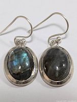 Front view of silver earrings with labradorite stones showing iridescent blue flashes.