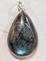 Front view of teardrop labradorite stone pendant with visible iridescent reflections in the gemstone within silver bezel setting.