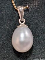 Close-up of the freshwater pearl pendant showing the pearl's lustrous surface and silver bail attachment.