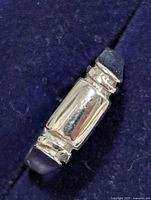 Front angled view of silver ring showing the polished rectangular central design and geometric accents.