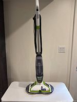 Front view of Bissell SpinWave electric mop showing brand and mop head including cord wrapped around handle.