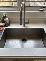 Overall installed view of sink and faucet in countertop beneath window