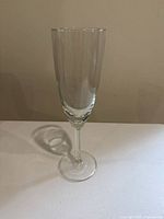 Single clear glass champagne flute shown to illustrate design, material, size and shape.