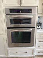Front view of stainless steel built-in microwave and oven unit installed in cabinetry