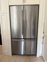 Closed stainless steel French door refrigerator installed in cabinetry