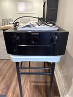 Front view showing receiver, power cable and manual on top