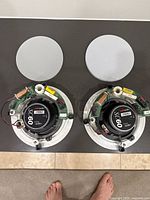 Pair of Polk Audio SC60 in-ceiling speakers shown with two white circular speaker grilles placed above each speaker.