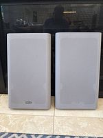 Front view of the two Yamaha YST-SF50 speakers side by side with gray fabric grills and Yamaha logos.