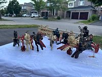 Full front view of the five horse-drawn wagons with horses, driver and fireman figures arranged on white cloth outdoors.