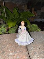 Front angle of the white ceramic ballerina figurine with pink and purple accents showing detailed dress and pose.